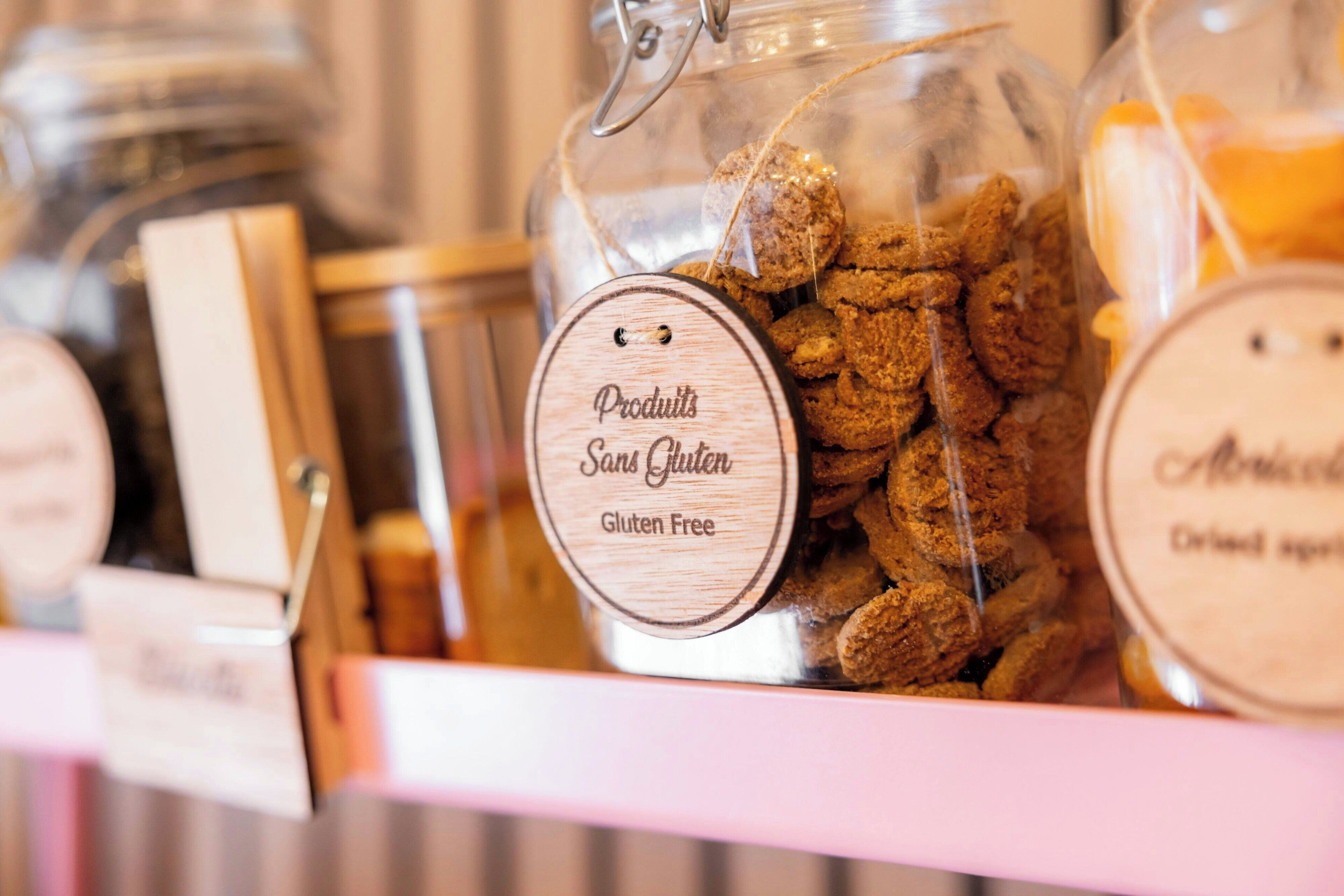 A display of gluten-free products in glass jars with wooden labels.
