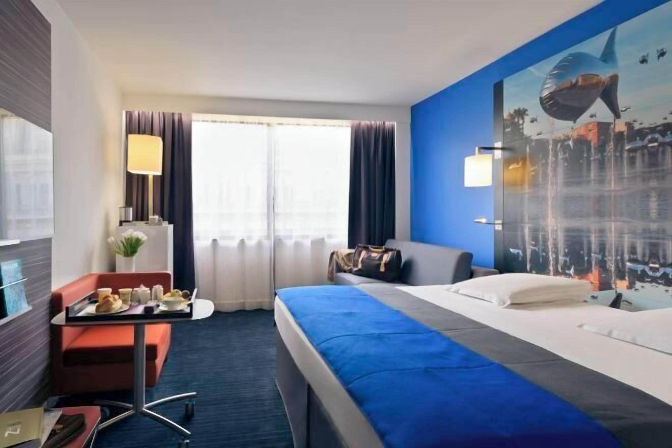 أغطية فراش متميزة وخزنة داخل الغرفة ومكتب وستائر تعتيم