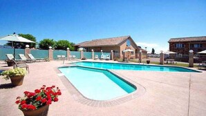 A swimming pool with lounge chairs and a building in the background.