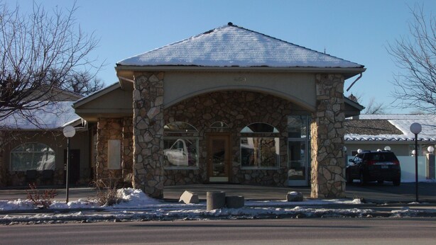 A stone building with a snow-covered roof and a clear sky.