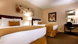Une chambre d’hôtel avec deux lits, un bureau et une chaise.