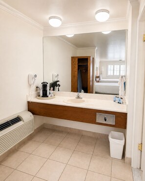 A modern bathroom with a large mirror, a sink, a towel rack, and a heater. - Econo Lodge Inn & Suites Vernal near Dinosaur Monument (Vernal)