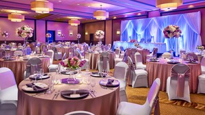 A banquet hall with round tables, white chairs, and purple accents. - Four Points by Sheraton Milwaukee North Shore (Milwaukee)