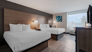 A hotel room with two beds, a desk, a TV, and a large window. - Best Western Corpus Christi Airport Hotel (Corpus Christi)