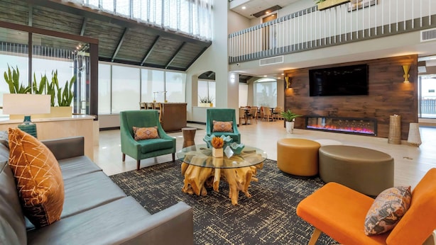 A spacious lobby with a high ceiling, a central seating area with a glass coffee table, and a fireplace. - Best Western Corpus Christi Airport Hotel (Corpus Christi)