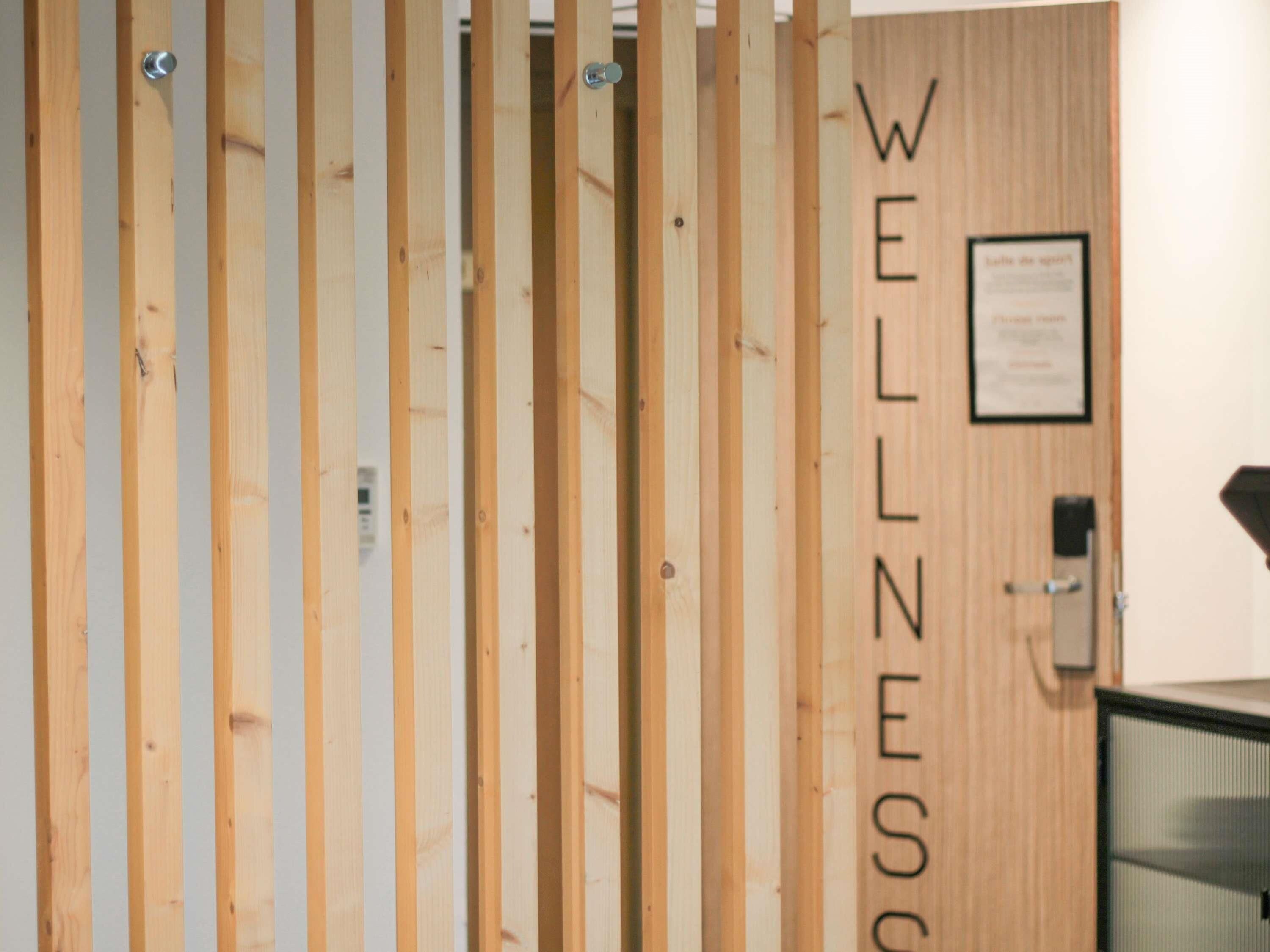 A wooden partition with the word "WELLNESS" vertically aligned.