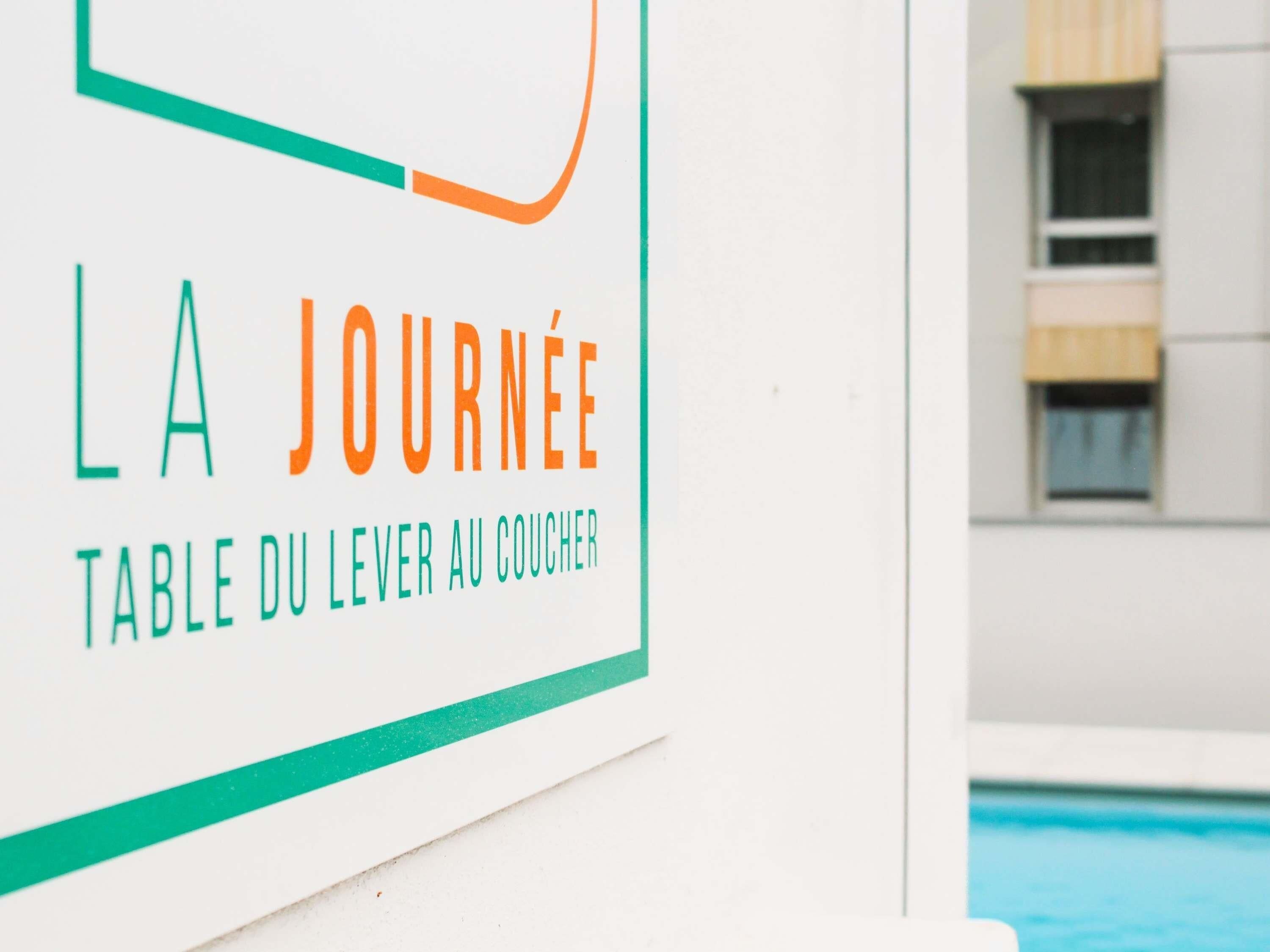 A sign with the text "LA JOURNÉE TABLE DU LEVER AU COUCHER".