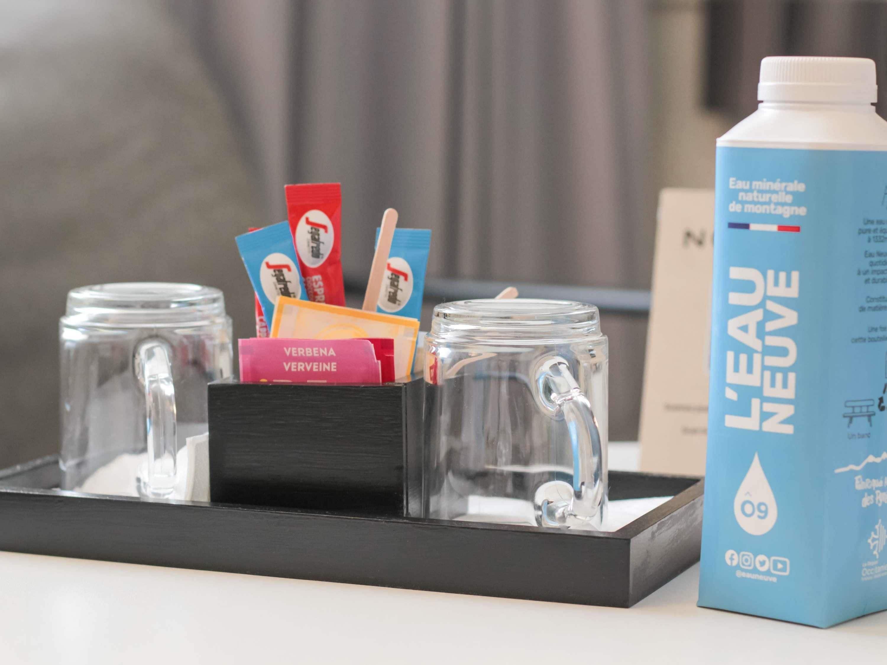 A tray with two glass jars, a blue water bottle, and some cards.
