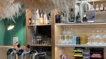 A bar area with multiple shelves of liquor bottles, glasses, and a beer tap.