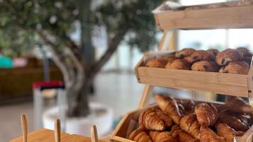 Une vitrine de boulangerie présentant des croissants et un présentoir en bois avec des ustensiles.