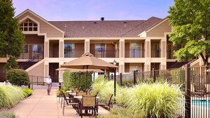 A hotel with outdoor seating, a pool, and a covered patio area. - Sonesta ES Suites Somerset (Somerset)