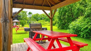 A wooden gazebo with a grill and picnic table in a lush green park. - Comfort Inn Midland (Midland)