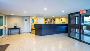 A modern hotel lobby with a reception desk, a water dispenser, and a glass door leading outside. - Comfort Inn Midland (Midland)