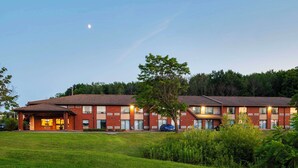 A multi-story brick building with a flat roof, large windows, and a well-maintained lawn in front. - Comfort Inn Midland (Midland)