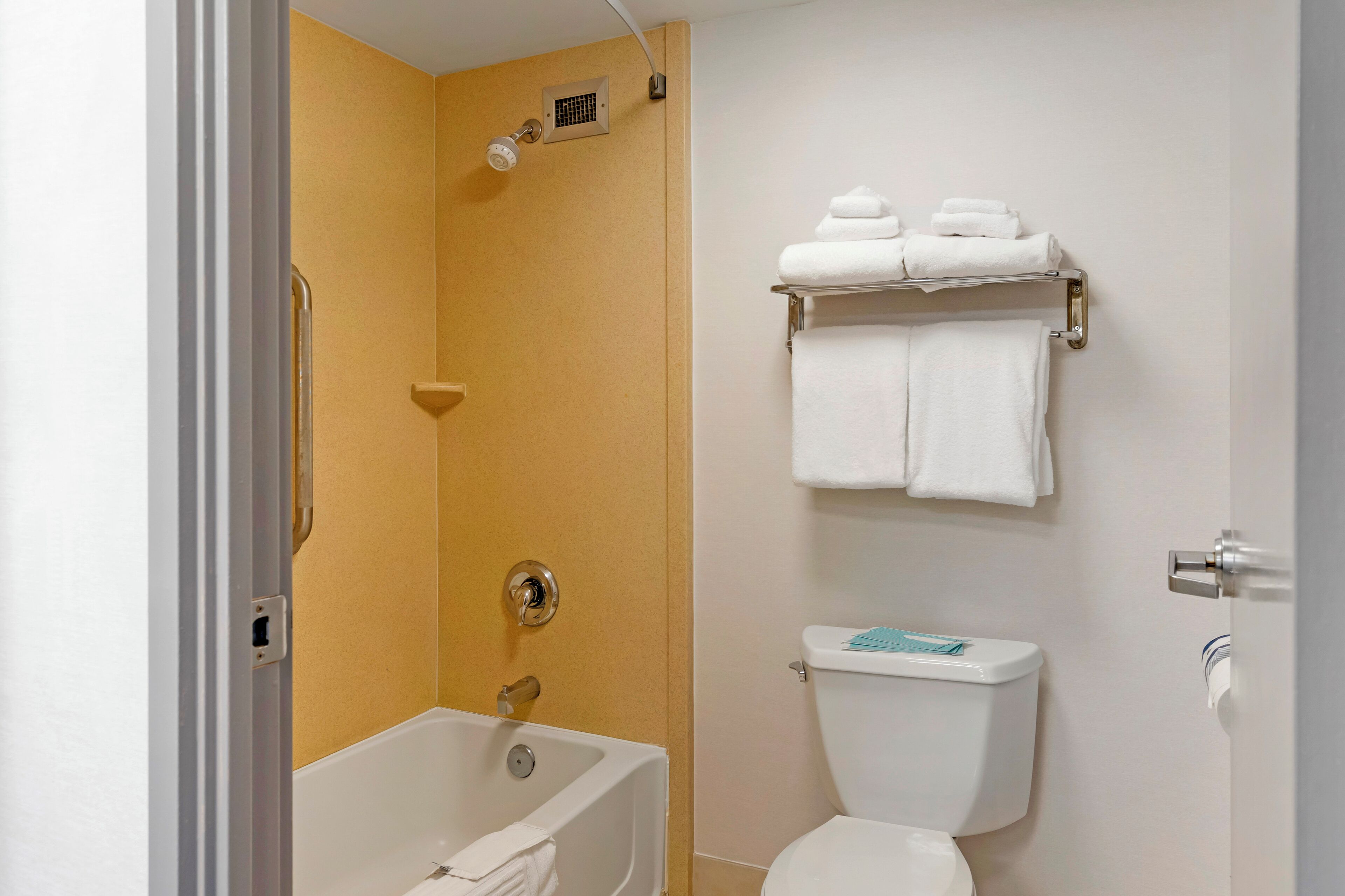 Ein Badezimmer mit Badewanne, Toilette und Handtuchhalter.