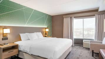 A hotel room with a large bed, bedside tables with lamps, a chair, a window with curtains, and a view of the city.