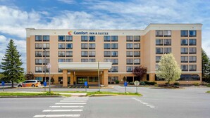 A Comfort Inn & Suites hotel with a modern design, featuring a central entrance, multiple floors, and a parking lot. - Comfort Inn & Suites Watertown - 1000 Islands (Watertown)