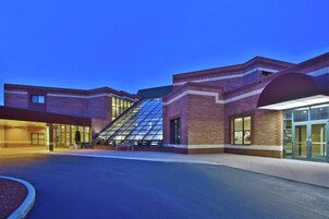A modern building with a glass facade, a ramp, and a set of double doors.