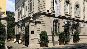 Un bâtiment historique doté de fenêtres en arc de cercle, d’une enseigne bien visible et d’une entrée fermée par un portail.