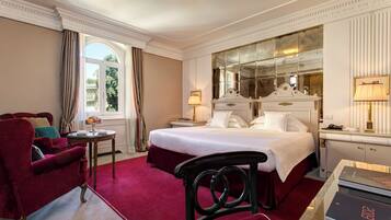 Ein Hotelzimmer mit einem großen Bett, einem roten Sofa, einem kleinen Tisch und einem Spiegel.