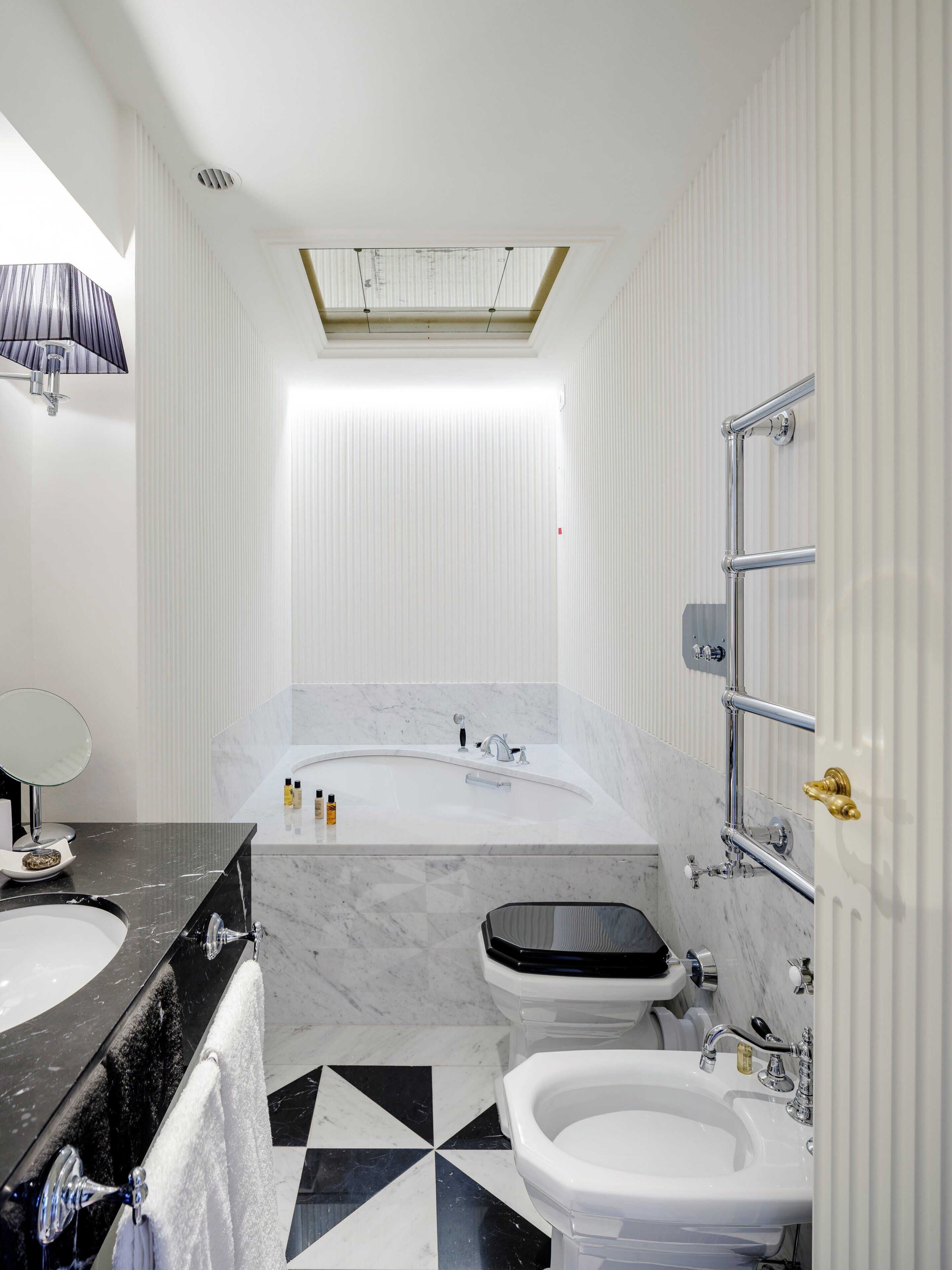 A modern bathroom with a large bathtub, a separate toilet, and a bidet.