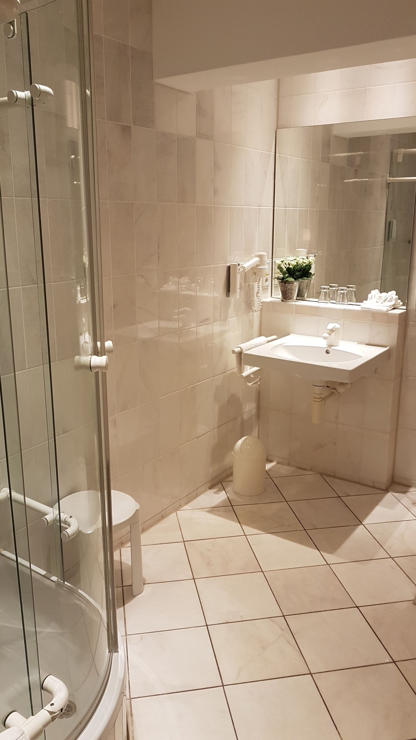 Ein Badezimmer mit Duschkabine, Waschbecken und Toilette.