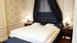 A neatly made bed with white linens, a dark blue canopy, and two bedside tables with lamps. - Best Western Plus Hotel StadtPalais (Braunschweig)