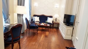 A hotel room with a sofa set, a television, and a wooden floor. - Best Western Plus Hotel StadtPalais (Braunschweig)