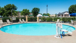 A swimming pool with lounge chairs and a lifeguard stand. - Baymont by Wyndham Clarksville Northeast (Clarksville)