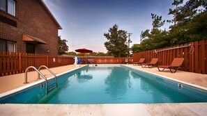 Una piscina al aire libre, tumbonas