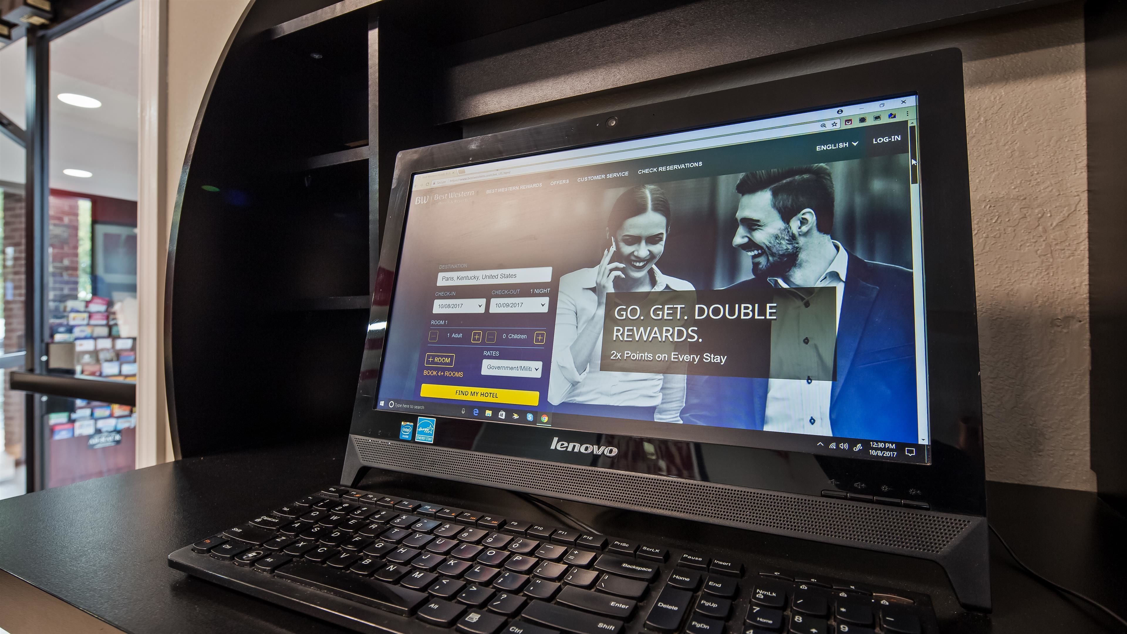 A Lenovo laptop displaying a hotel booking website with a promotional offer for double rewards.