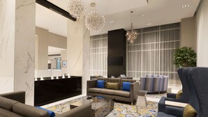 A modern living room with a sofa, armchairs, a coffee table, and a TV. - Embassy Suites by Hilton Toronto Airport (Toronto)