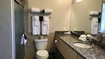 Un baño con inodoro, lavabo y toallero.