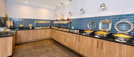 Una cocina moderna con armarios de madera, encimera negra y salpicadero de azulejos azules.
