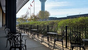 Una terraza con asientos al aire libre, vista a una torre de control y banderas.