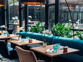 Interior de un restaurante con mesas, sillas y un sofá azul.