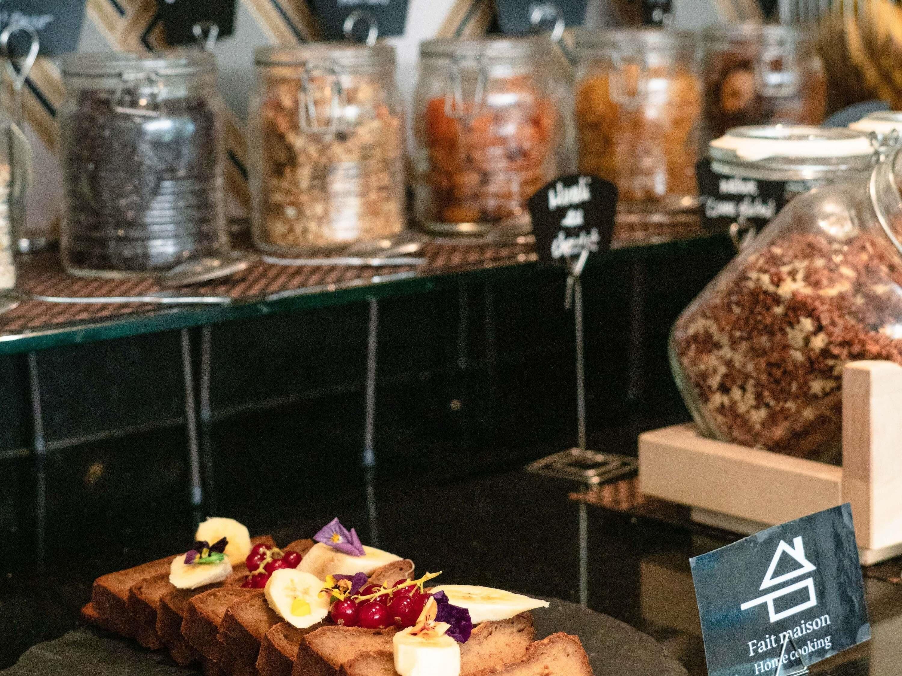 A bakery display with various jars of food items and a sign indicating home cooking.