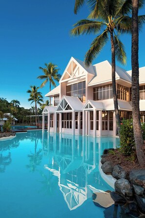 A resort with a large pool, palm trees, and a modern building with large windows. - Sheraton Grand Mirage Resort, Port Douglas (Port Douglas)