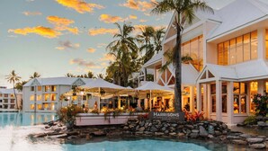 A resort with a pool, palm trees, and a building with a sign reading "HARRISONS". - Sheraton Grand Mirage Resort, Port Douglas (Port Douglas)