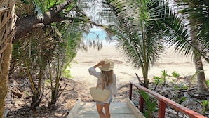A wooden pathway leading to a beach, surrounded by palm trees and tropical vegetation. - Sheraton Grand Mirage Resort, Port Douglas (Port Douglas)