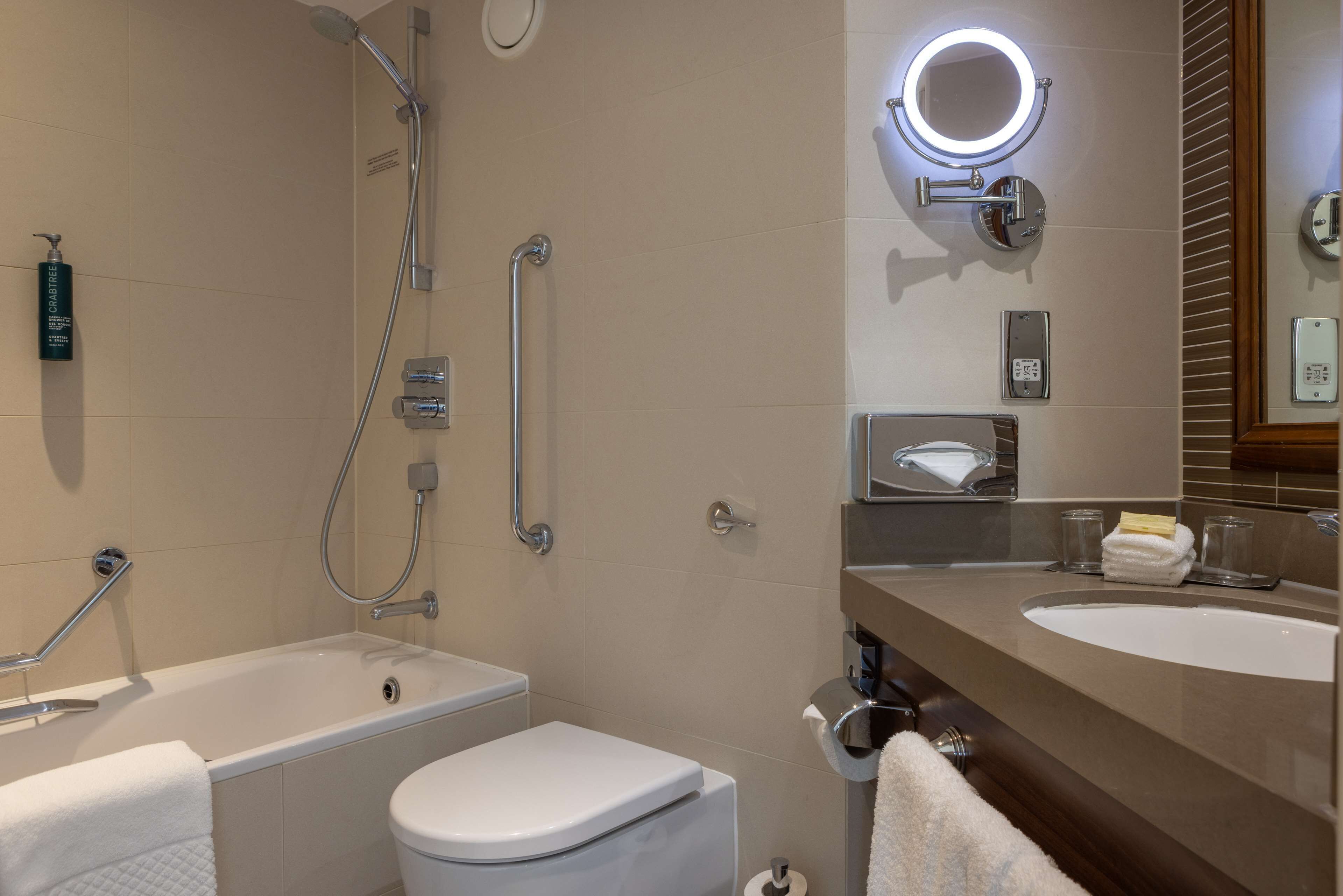 A modern bathroom with a bathtub, toilet, and sink.
