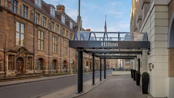 A hotel entrance with a sign reading "Hilton" above a covered walkway.