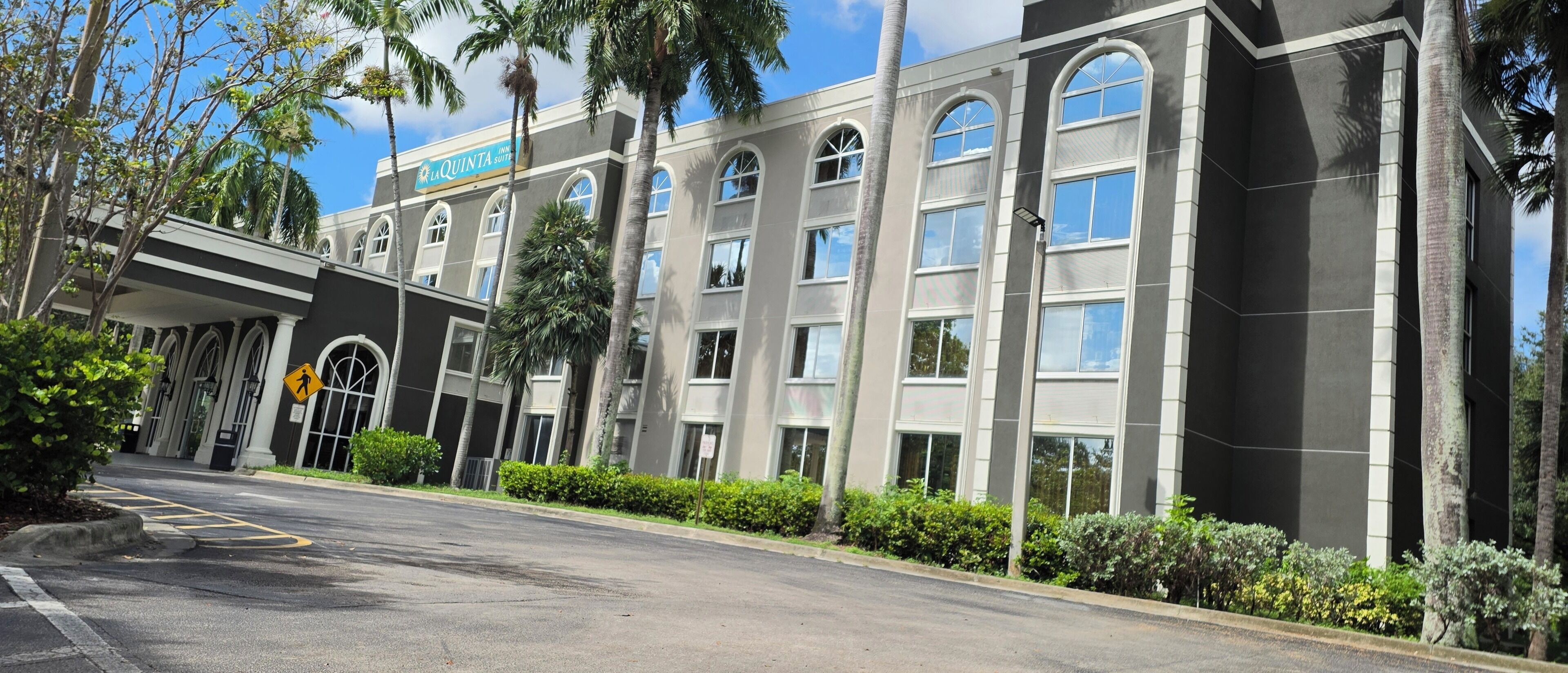 A hotel building with a modern facade, multiple windows, and a sign indicating it is a La Quinta Inn & Suites.