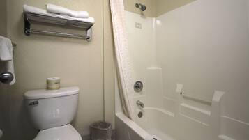 A bathroom with a toilet, a shower, and a towel rack.