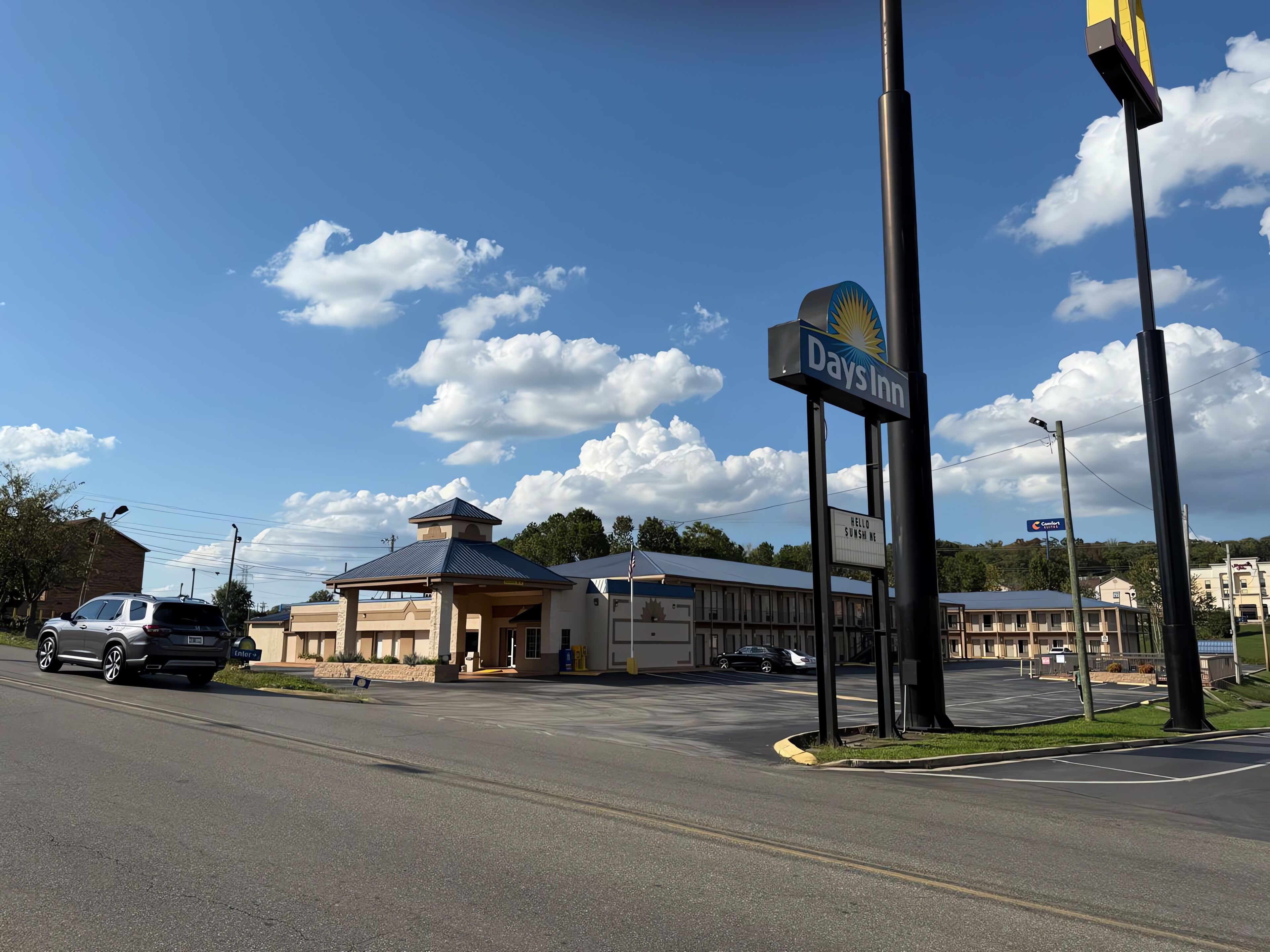 A Days Inn with a large sign, a covered entrance, and a parking lot.