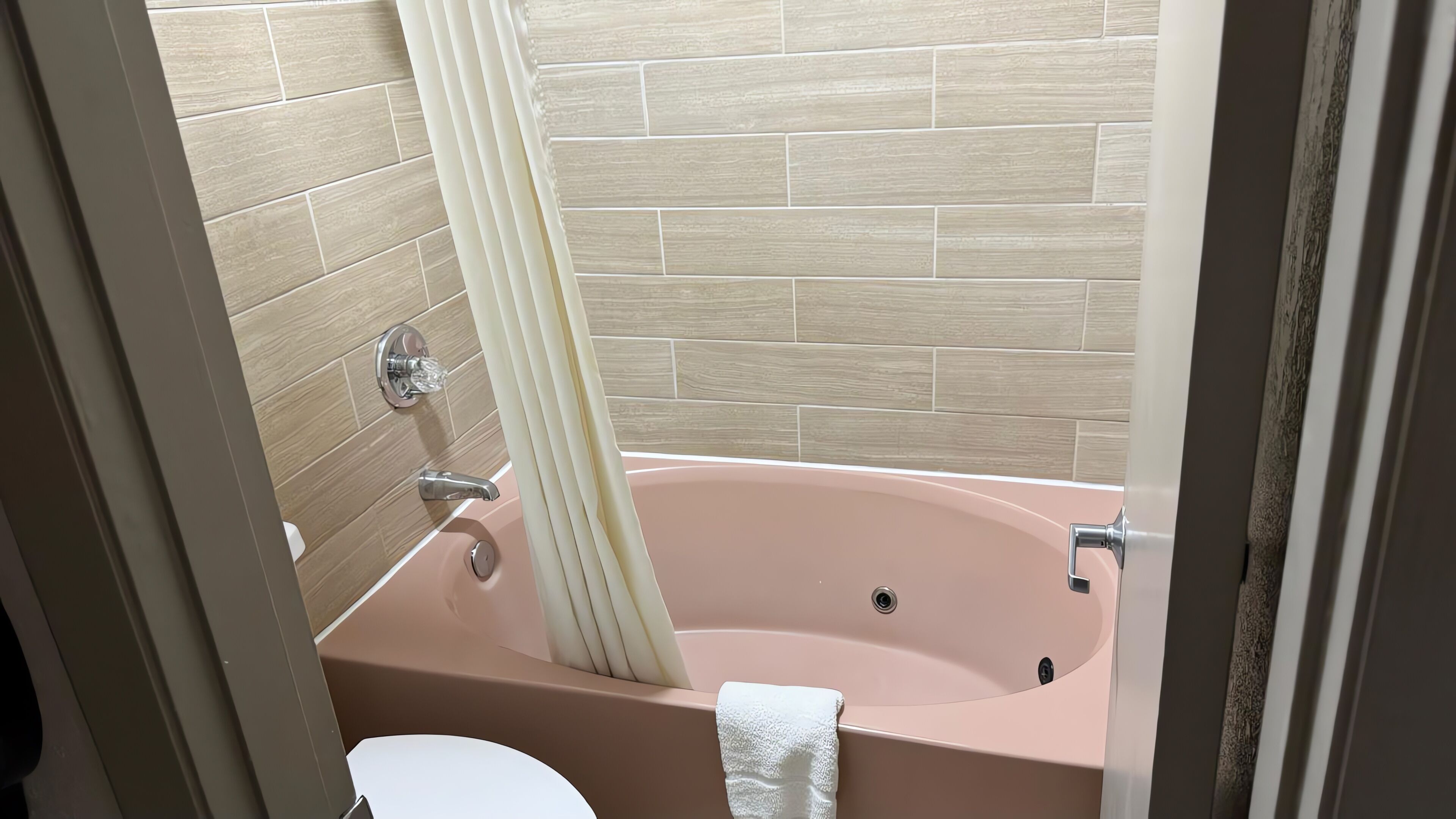 A bathroom with a bathtub, a toilet, and a shower curtain.