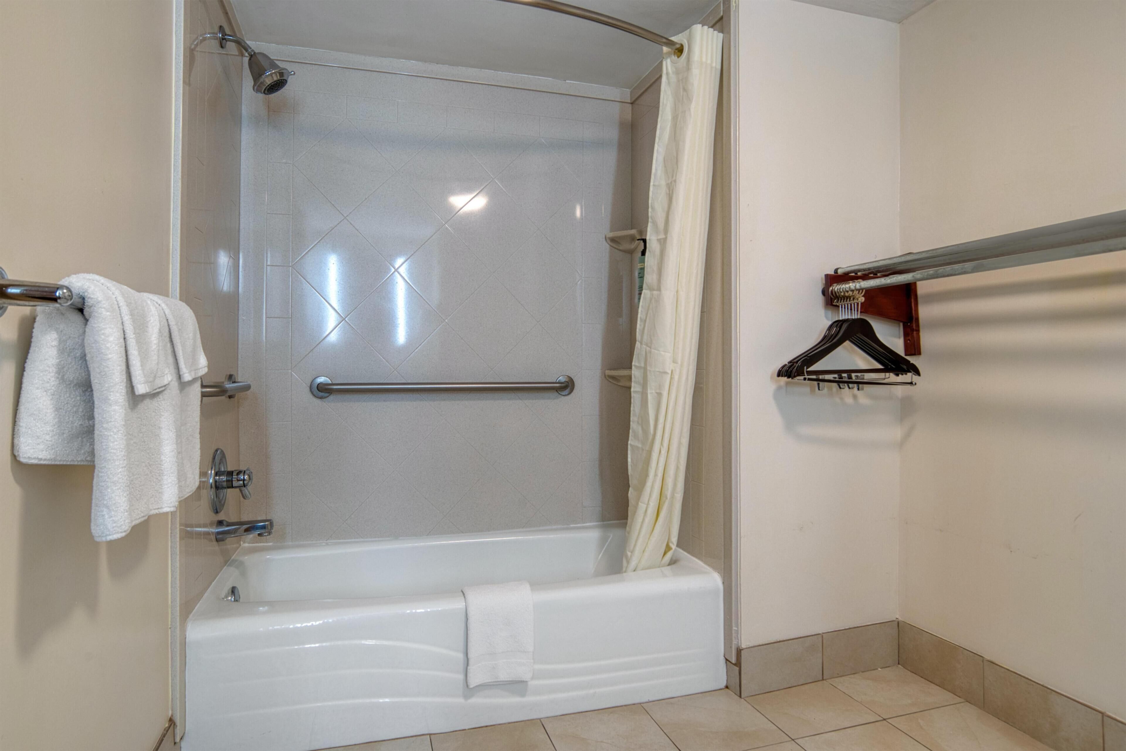 Une salle de bain avec une baignoire, un rideau de douche, un porte-serviettes et une serviette.