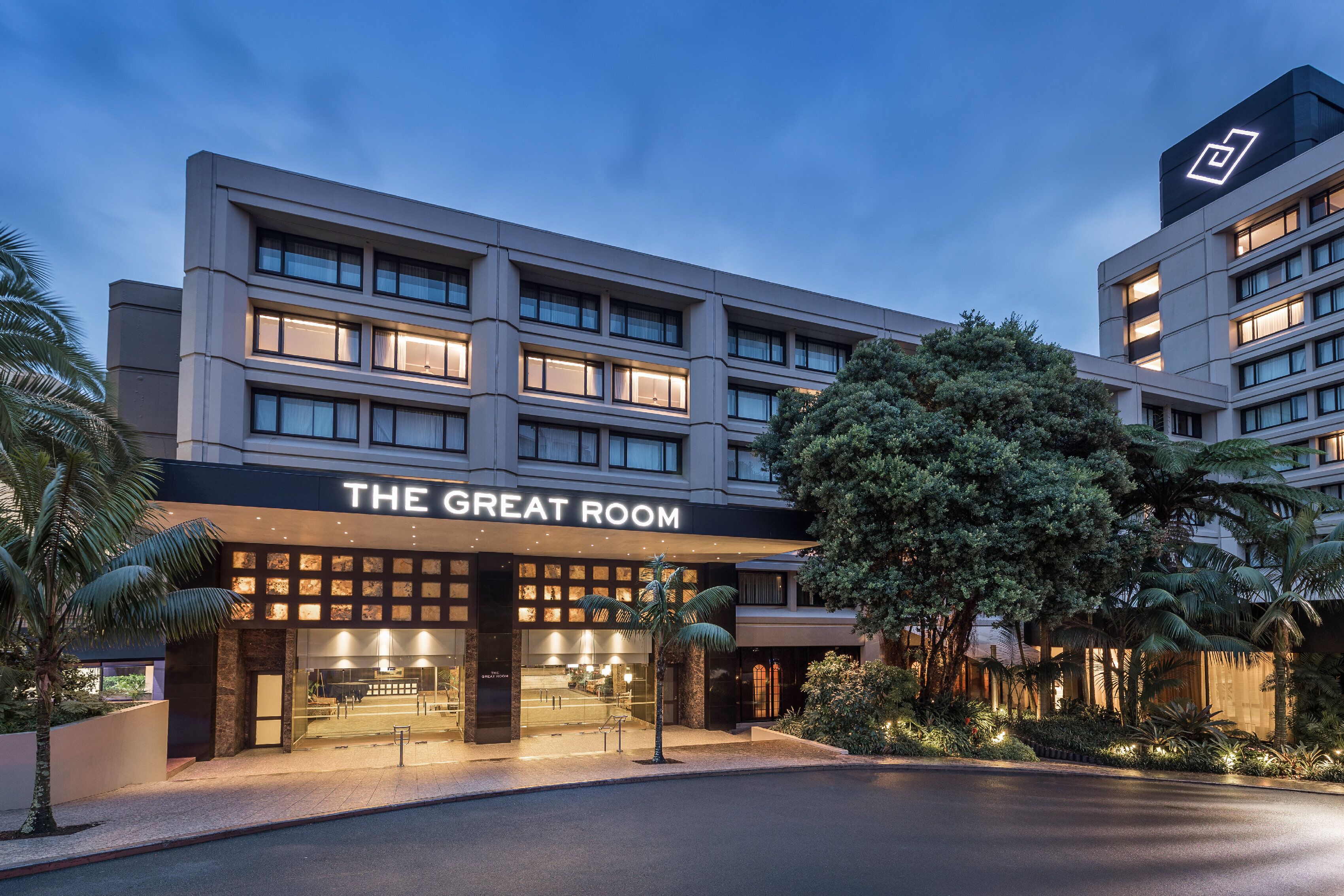 A hotel with a modern facade, multiple floors, and a well-lit entrance.