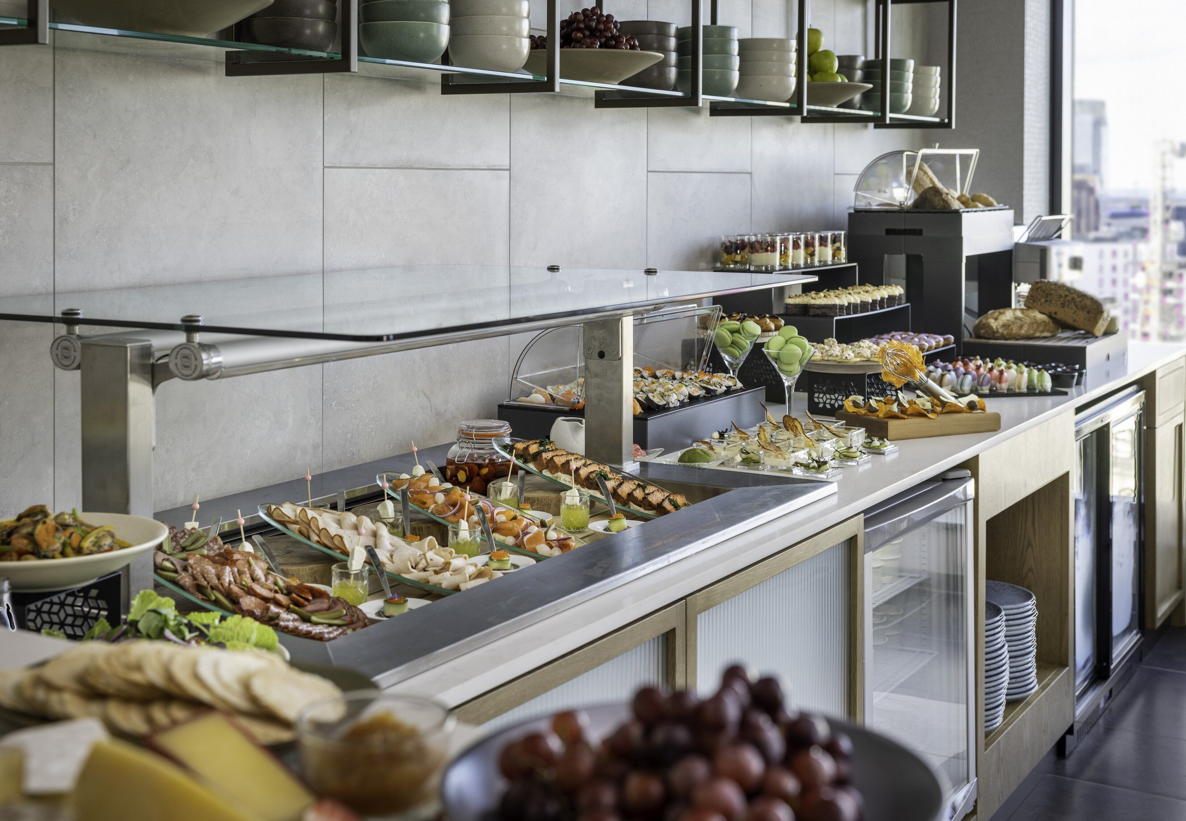 A buffet with various food items and a glass display case.