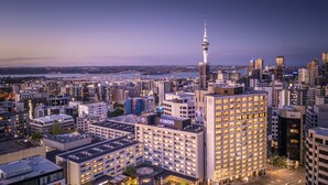 Een hotel met een opvallende toren en uitzicht op een stadshemelbeeld.